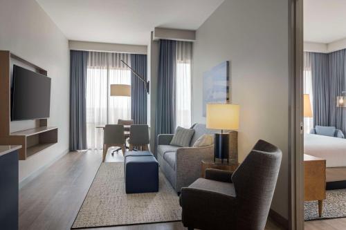 a hotel room with a bed and a living room at Embassy Suites By Hilton Bowling Green in Bowling Green
