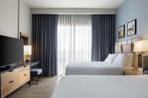 a hotel room with two beds and a flat screen tv at Embassy Suites By Hilton Bowling Green in Bowling Green