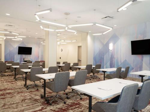 a conference room with tables and chairs and screens at Hilton Garden Inn Jeffersonville, In in Jeffersonville
