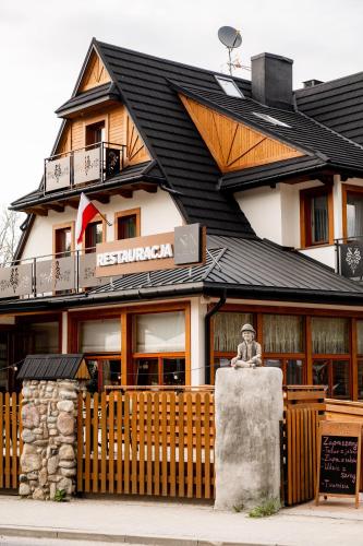 a building with a statue in front of it at Ku Dolinie in Kościelisko