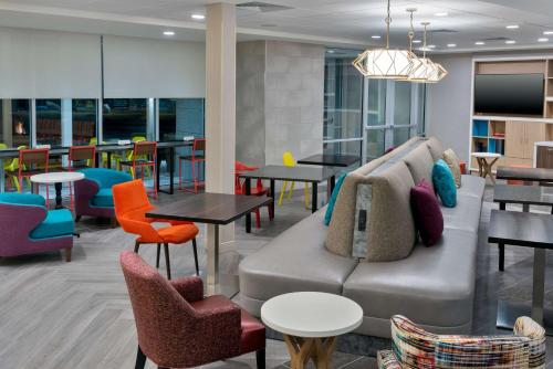 a lobby with a couch and tables and chairs at Home2 Suites By Hilton Wildwood The Villages in Wildwood