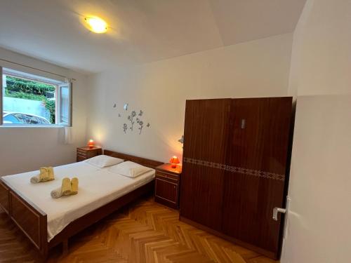 een kleine slaapkamer met een bed en een kast bij Apartman Ivica in Omiš