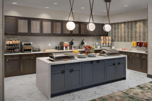 Una cocina con gabinetes marrones y una encimera. en Homewood Suites By Hilton Louisville Airport, en Louisville