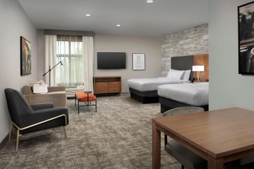 a hotel room with two beds and a tv at Homewood Suites By Hilton Louisville Airport in Louisville
