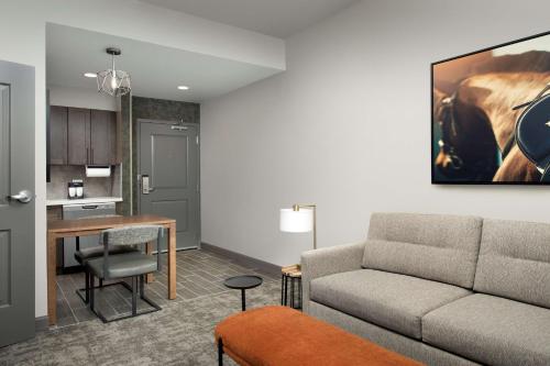 a living room with a couch and a table at Homewood Suites By Hilton Louisville Airport in Louisville