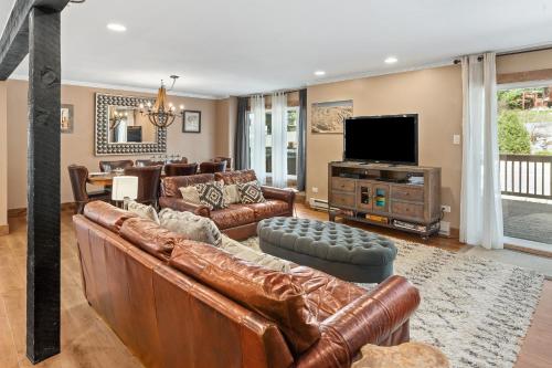 uma sala de estar com mobiliário de couro e uma televisão de ecrã plano em Winterset 1 condo em Steamboat Springs