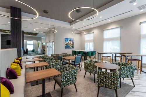 a dining room with tables and chairs and windows at Hilton Garden Inn St Augustine-Historic District in Saint Augustine