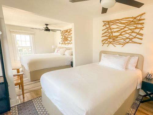 a bedroom with two beds and a ceiling fan at Beachliner Hotel in Ocean Grove