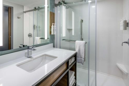 a white bathroom with a sink and a shower at Hilton Garden Inn St Augustine-Historic District in Saint Augustine