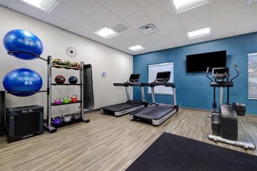 a gym with tread machines and a flat screen tv at Hampton Inn & Suites Marina in Marina
