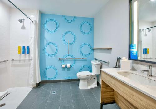 a bathroom with a toilet and a blue wall at Tru By Hilton San Antonio At The Rim, Tx in San Antonio