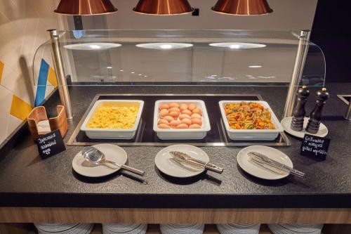 a buffet with eggs and other food on a counter at Hampton By Hilton Poznan Swarzedz in Swarzędz