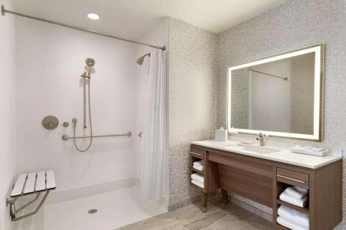 a bathroom with a sink and a mirror and a tub at Home2 Suites By Hilton Alamogordo White Sands in Alamogordo