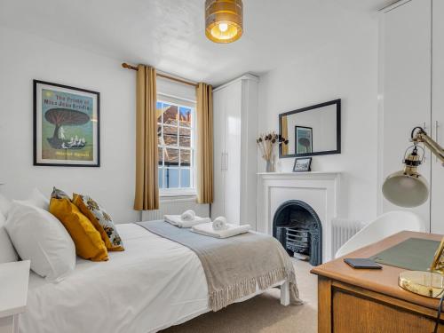 a white bedroom with a bed and a fireplace at Pass the Keys A Period Building in the Heart of Canterbury in Canterbury