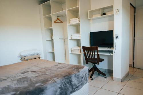 a bedroom with a bed and a desk with a computer at Irová Apart Hotel in Posadas