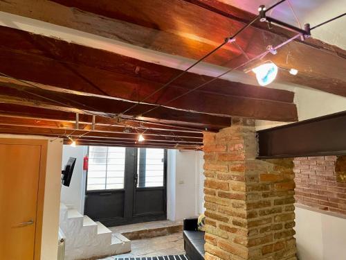 a room with a brick wall and a black door at Duplex de encanto en Part Alta! in Tarragona