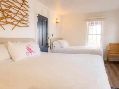 two beds in a room with two white beds at Beachliner Hotel in Ocean Grove