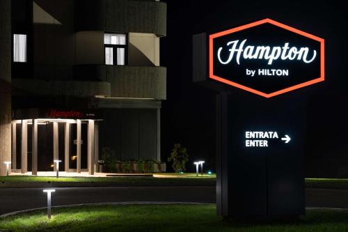 a sign in front of a building at night at Hampton by Hilton Rome North Fiano Romano in Fiano Romano