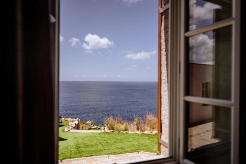 a view of the ocean from a window at Faro di Punta Fenaio in Campese