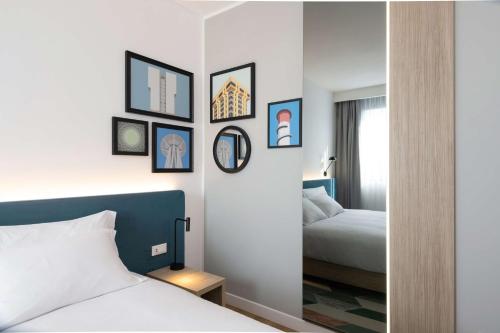 菲亚诺罗马诺Hampton by Hilton Rome North Fiano Romano的卧室配有镜子,位于床边