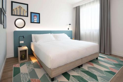 菲亚诺罗马诺Hampton by Hilton Rome North Fiano Romano的卧室配有一张白色大床和地毯。