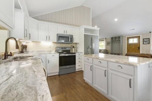 a large kitchen with white cabinets and a counter top at Mill Stream Cottage in Pigeon Forge