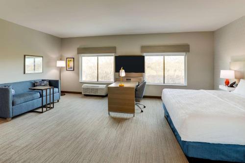 Großes Hotelzimmer mit einem Bett und einem Sofa in der Unterkunft Hampton Inn & Suites Weatherford, Tx in Weatherford
