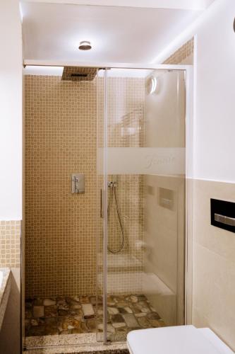 a shower with a glass door in a bathroom at Faro di Punta Fenaio in Campese