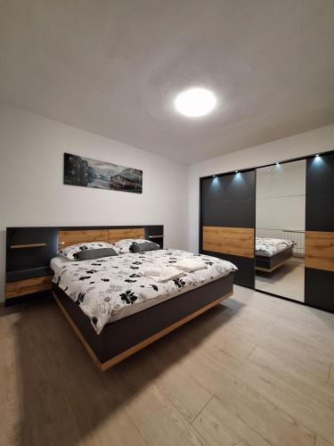 - une chambre avec un grand lit et un grand miroir dans l'établissement Apartma Kanal, à Kanal
