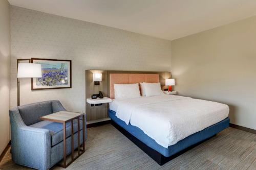 a hotel room with a bed and a chair at Hampton Inn & Suites Weatherford, Tx in Weatherford