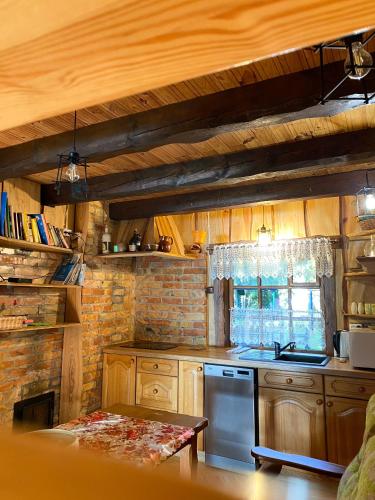 a kitchen with wooden cabinets and a stove top oven at Czerwony domek nad samym jeziorem in Mikołajki