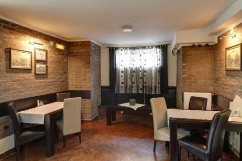 um restaurante com paredes de tijolos, mesas e cadeiras em Hotel PERLA LESKOVAC em Leskovac