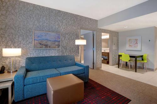 a living room with a blue couch and a table at Home2 Suites By Hilton Lakewood Ranch in Bradenton