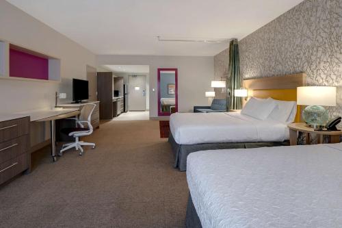 a hotel room with two beds and a desk at Home2 Suites By Hilton Lakewood Ranch in Bradenton