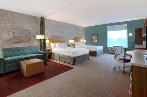 Home2 Suites By Hilton Lakewood Ranch في برادنتون: غرفة فندقية بسريرين واريكة