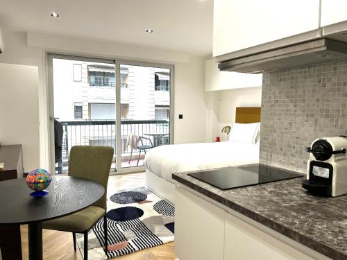 une chambre avec un lit et une cuisine avec une table dans l'établissement STUDIO MODERNE 5 mn PLAGES CROISETTE A0B191, à Cannes