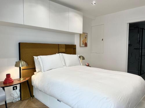 une chambre avec un grand lit blanc et une table dans l'établissement STUDIO MODERNE 5 mn PLAGES CROISETTE A0B191, à Cannes