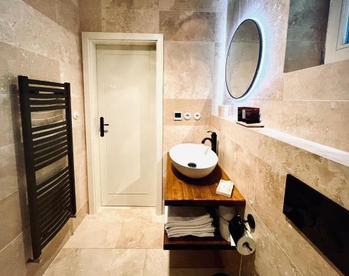 ein Bad mit einem Waschbecken und einem Spiegel in der Unterkunft Apartmány v Beskydech in Frenštát pod Radhoštěm