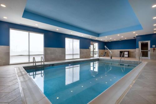 a swimming pool in a hotel with blue walls and windows at Hampton Inn Kansas City Southeast, Mo in Kansas City