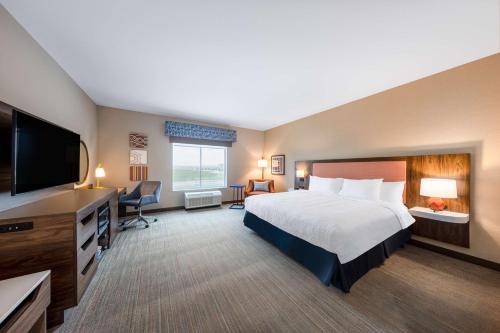 Hampton Inn Kansas City Southeast, Mo في كانساس سيتي: غرفة فندقية بسرير وتلفزيون بشاشة مسطحة