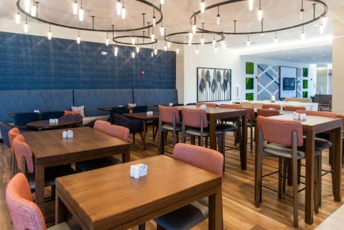 a dining room with wooden tables and chairs at Hilton Garden Inn Mattoon, IL in Mattoon
