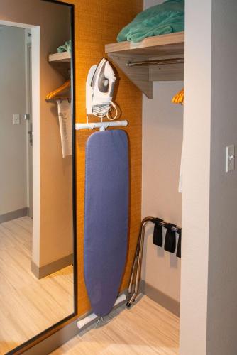 a mirror in a room with a skateboard on a shelf at Hilton Garden Inn Mattoon, IL in Mattoon
