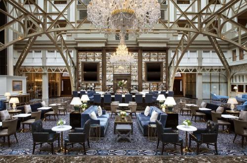 a lobby with a chandelier and tables and chairs at Waldorf Astoria Washington DC in Washington