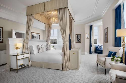 a bedroom with a canopy bed and a chair at Waldorf Astoria Washington DC in Washington