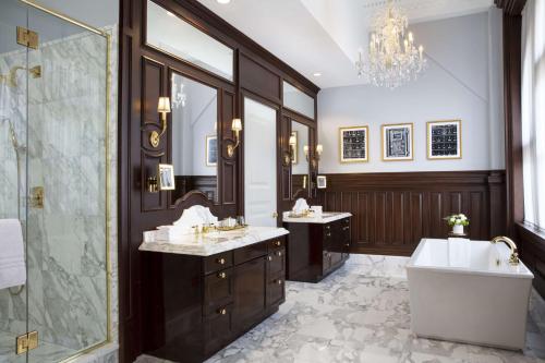 a bathroom with two sinks and a tub and a shower at Waldorf Astoria Washington DC in Washington