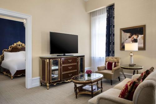 a living room with a television and a bed at Waldorf Astoria Washington DC in Washington