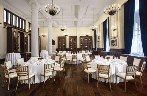 a banquet room with white tables and chairs and chandeliers at Waldorf Astoria Washington DC in Washington