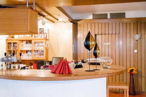 a kitchen with a bar with a counter with glasses at Hotel Garni Ratstube in Bad Urach