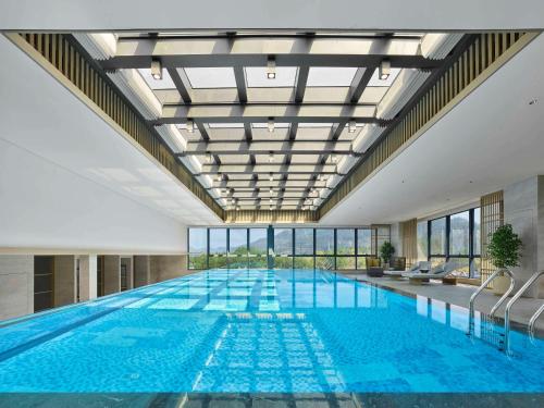 a large swimming pool in a building at Doubletree By Hilton Taizhou Shenxianju in Taizhou