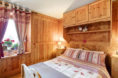 una camera con un letto e una parete in legno di Maison Grange 1 a Gressan